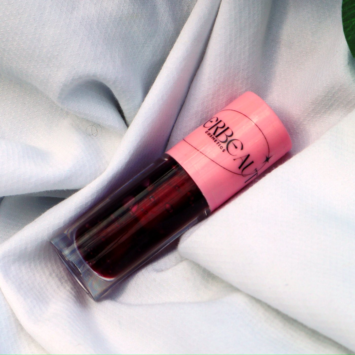 Lust, high shine pigmented tinting gloss, in a pink-capped MEERBEAUT wand tube